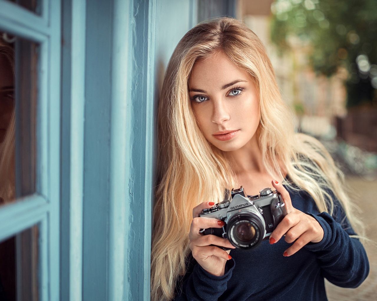 Красивая девушка блондинка с фотоаппаратом 