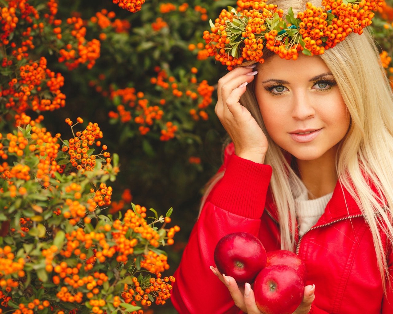 Красивая девушка с венком из рябины на голове и с красными яблоками в руках 