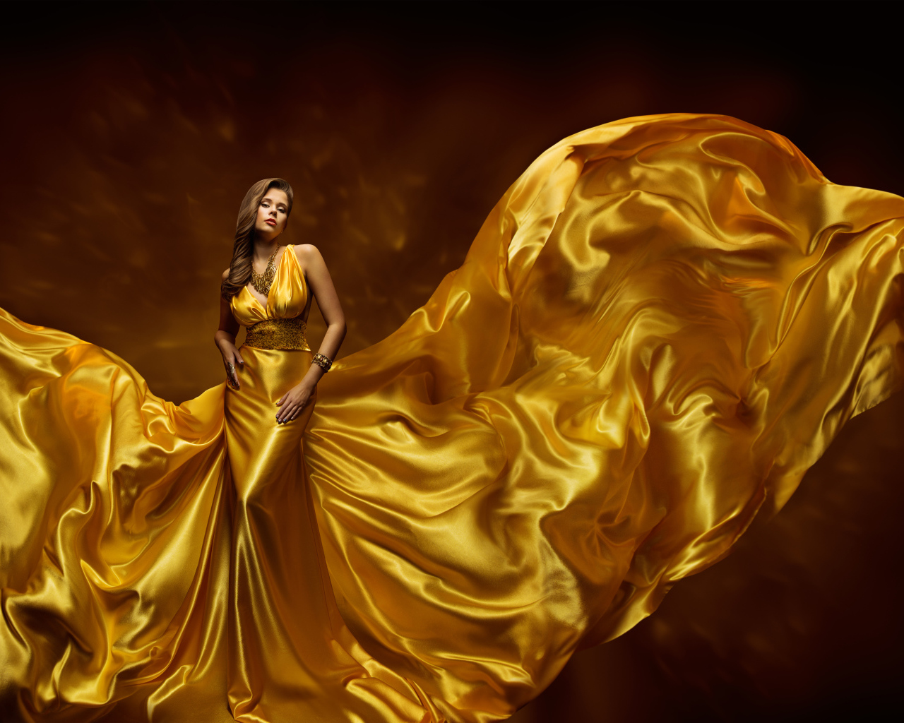 Красивая девушка шатенка в красивом платье золотого цвета