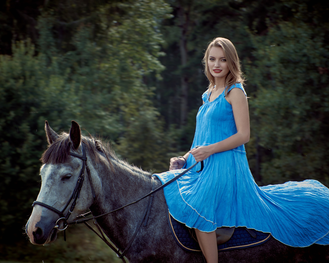 Девушка блондинка в голубом платье на лошади