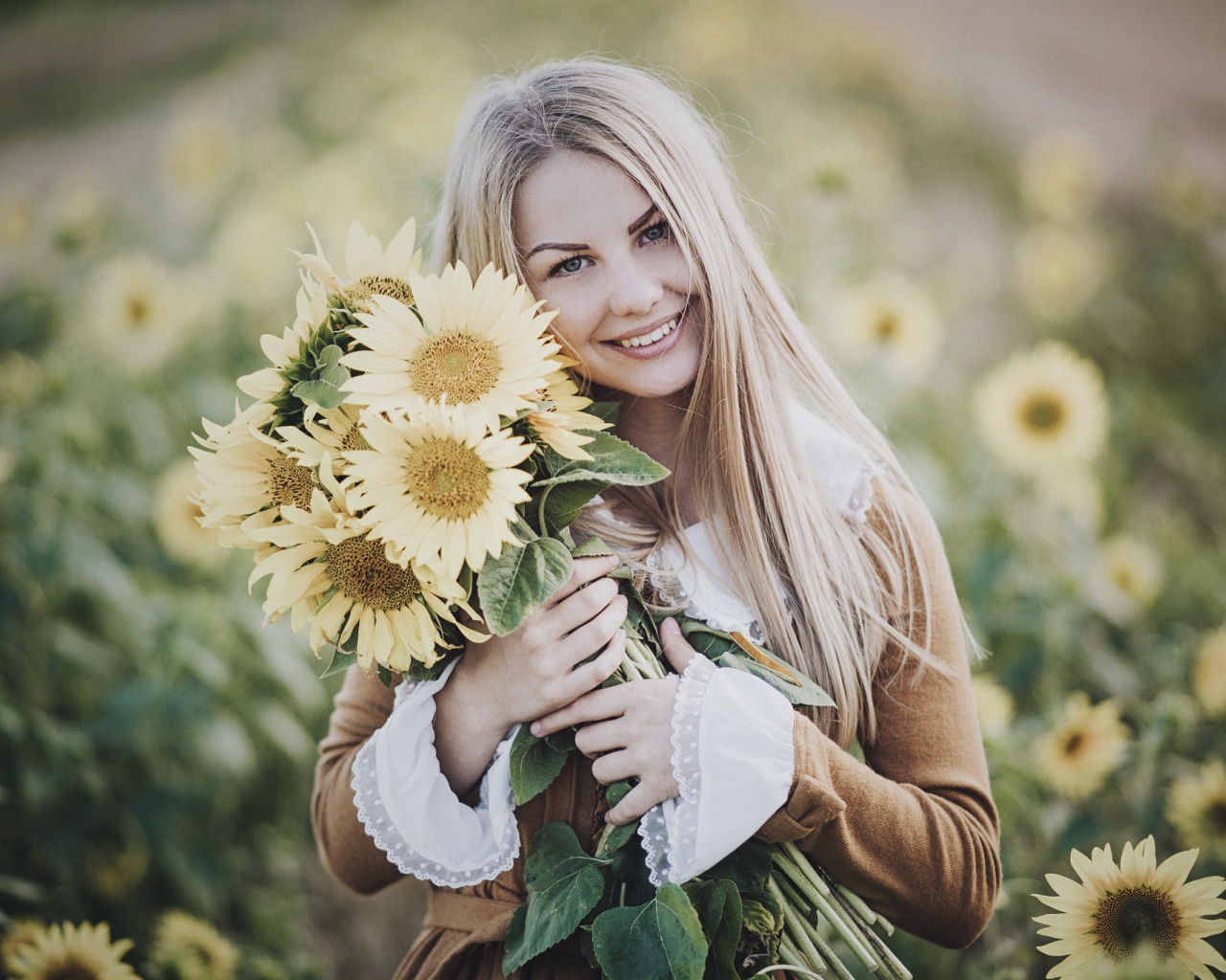 Милая улыбающаяся девушка с букетом цветов подсолнуха