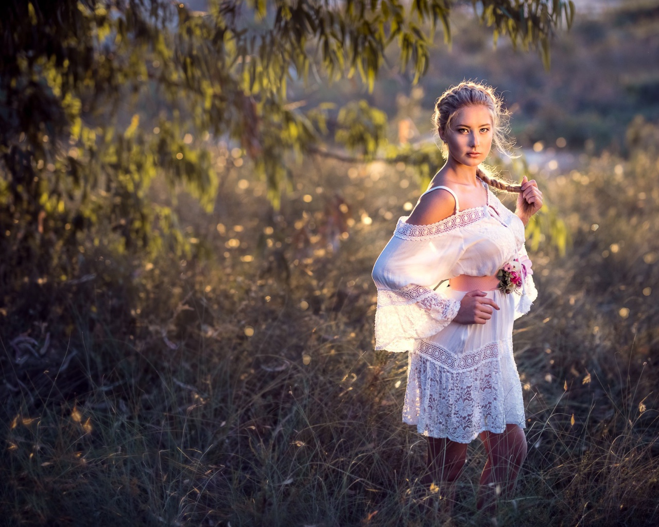 Молодая девушка модель в красивом белом платье с косой на голове