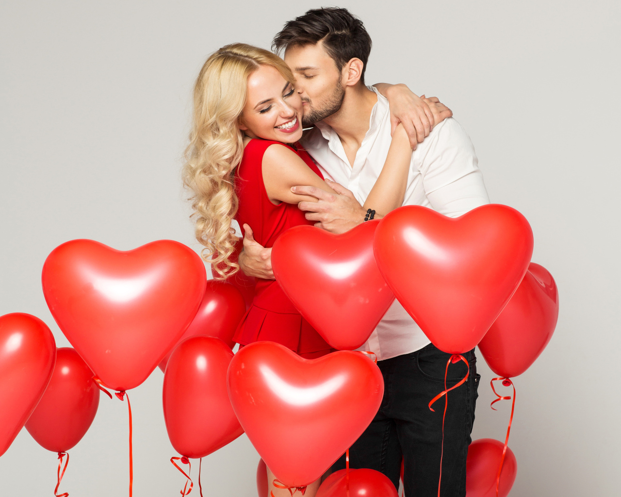 Счастливая влюбленная пара с воздушными шариками в форме сердца