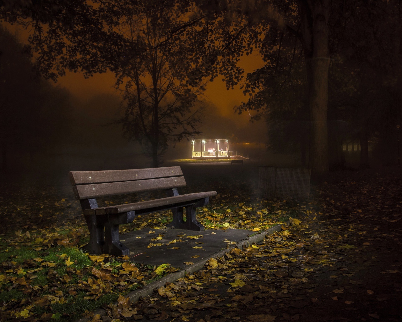 Одинокая скамейка в осеннем парке ночью