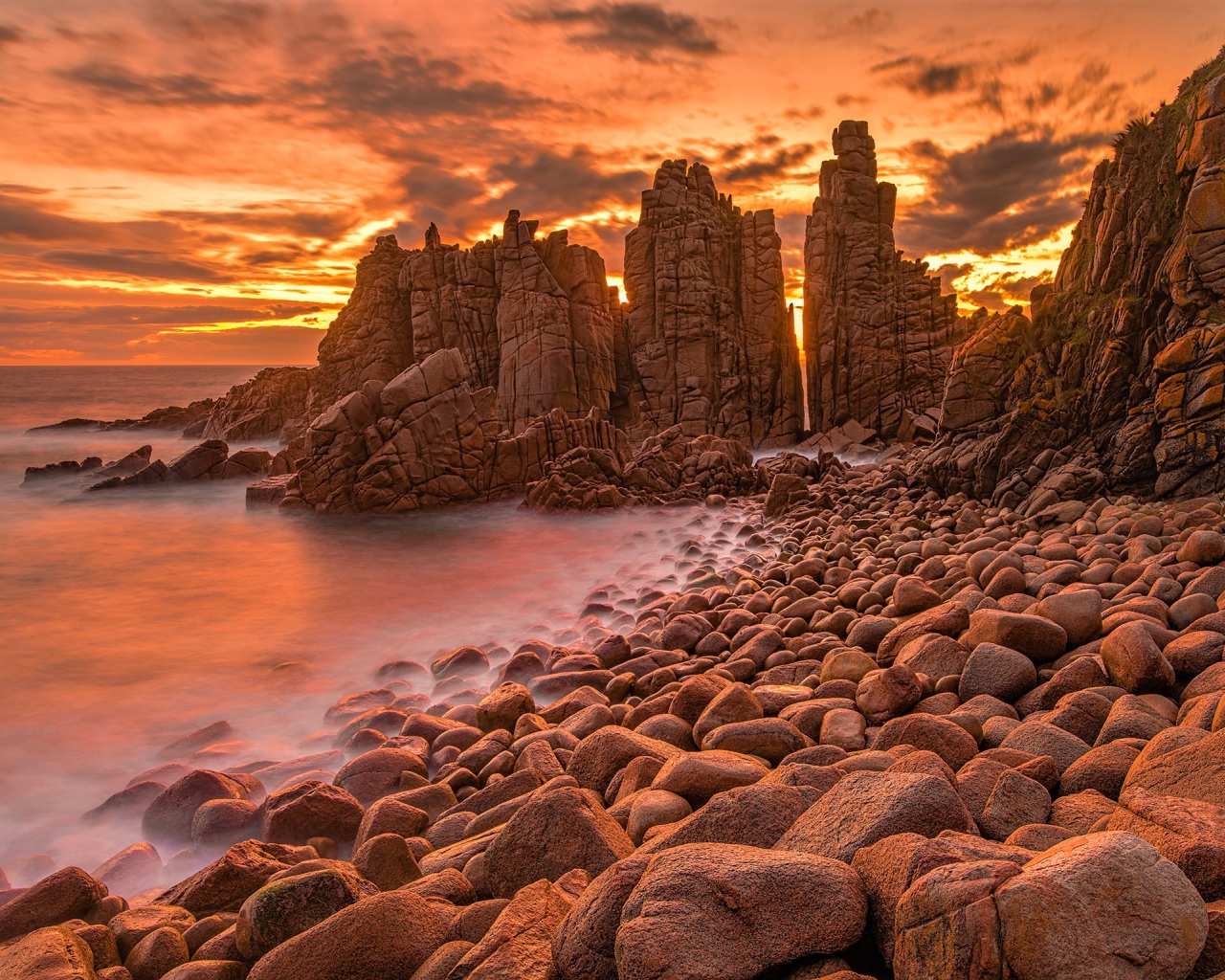Каменные скалы в океане на закате солнца