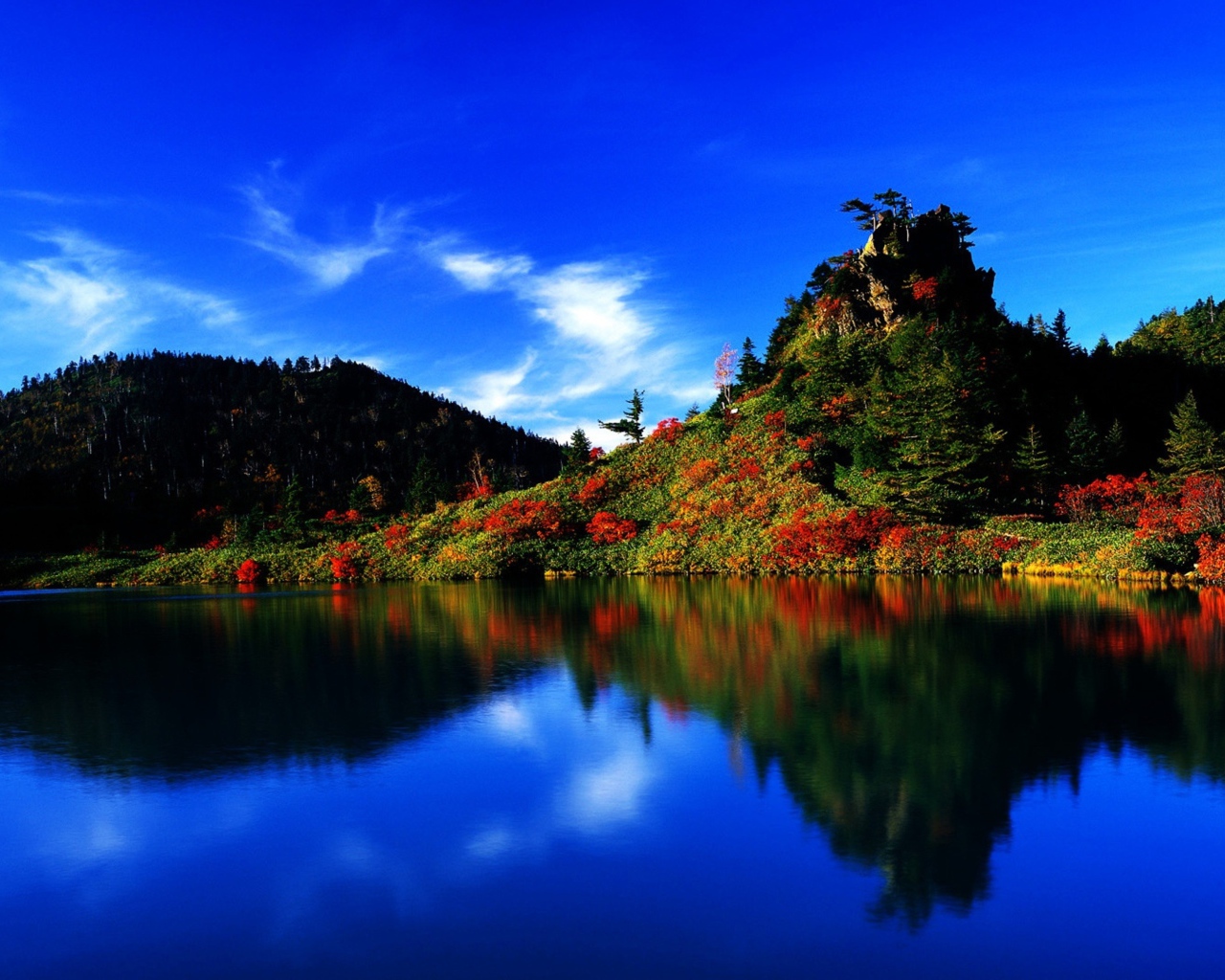 Голубое небо отражается в чистой воде озера 