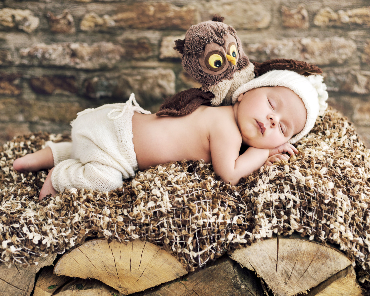 Грудной ребенок спит рядом с игрушкой совой