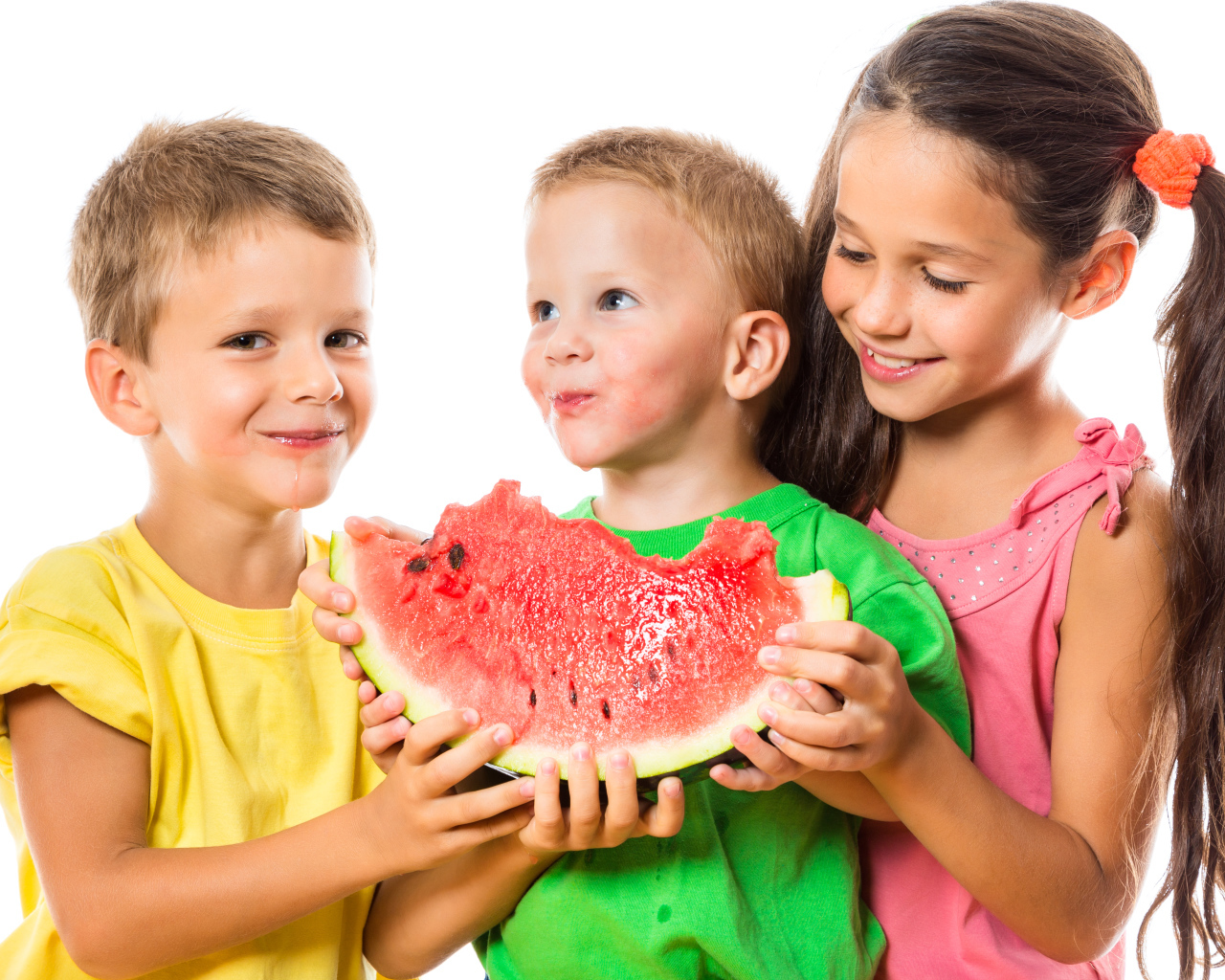 Два маленьких мальчика и девочка едят арбуз на белом фоне