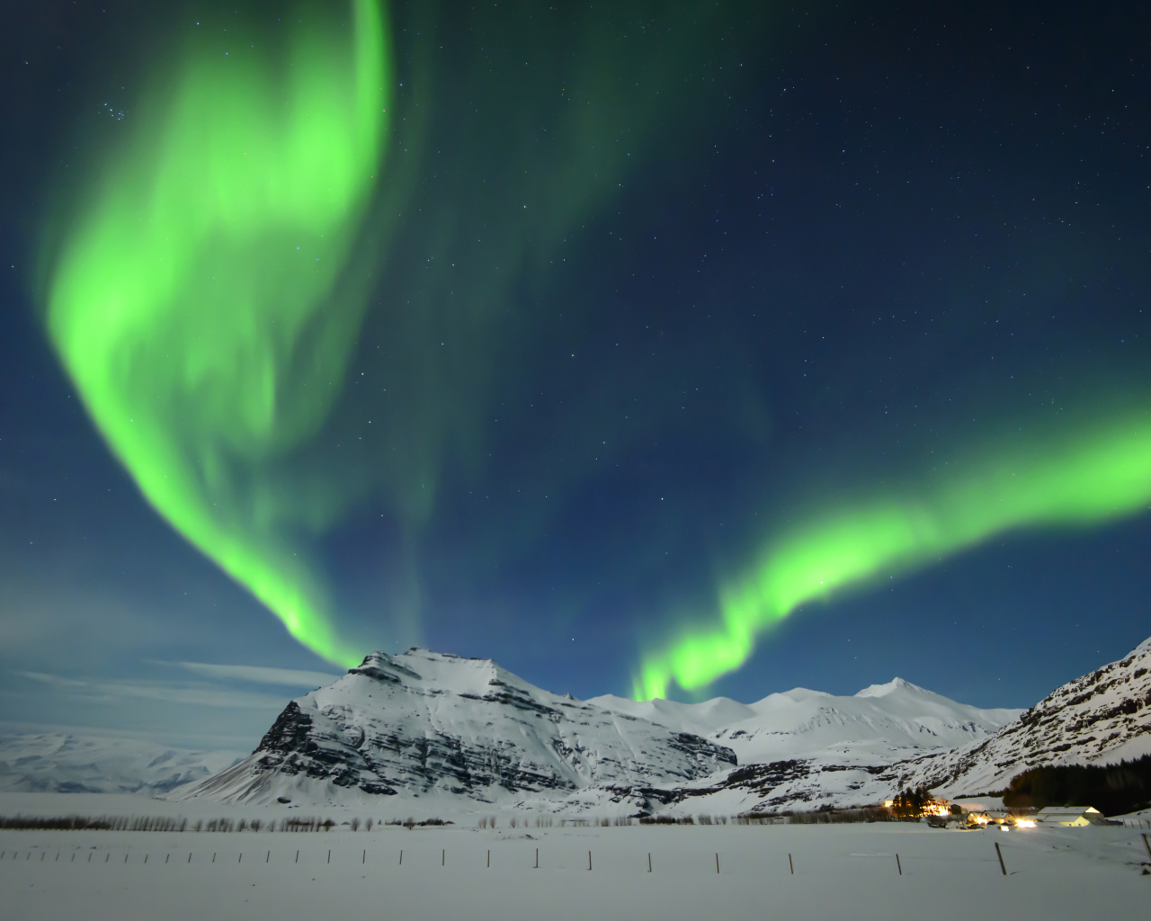 Полярное сияние в небе над заснеженными горами, Исландия