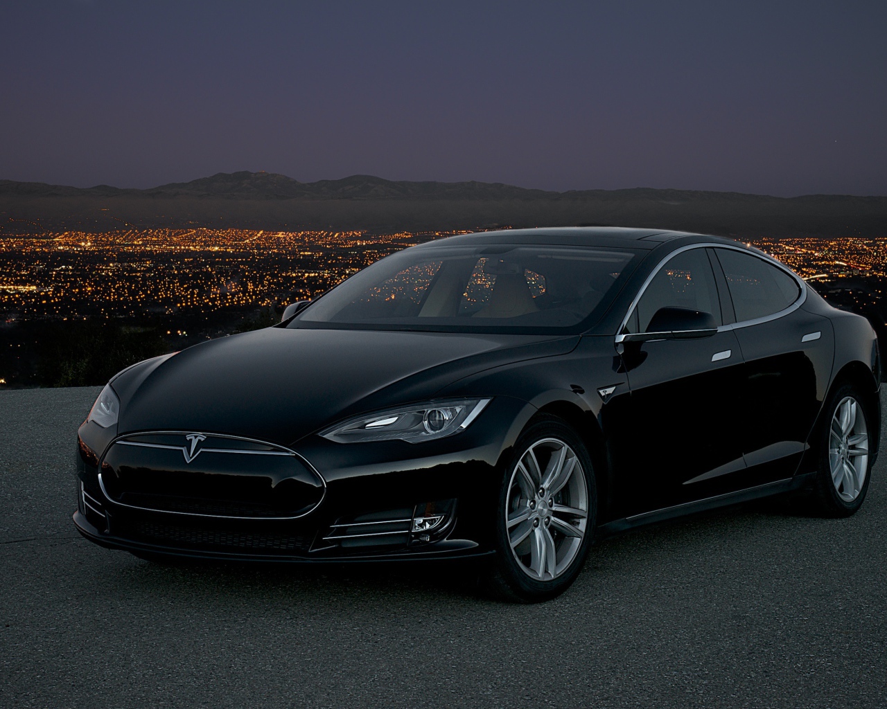 Black stylish electric Tesla Model S on the background of night city