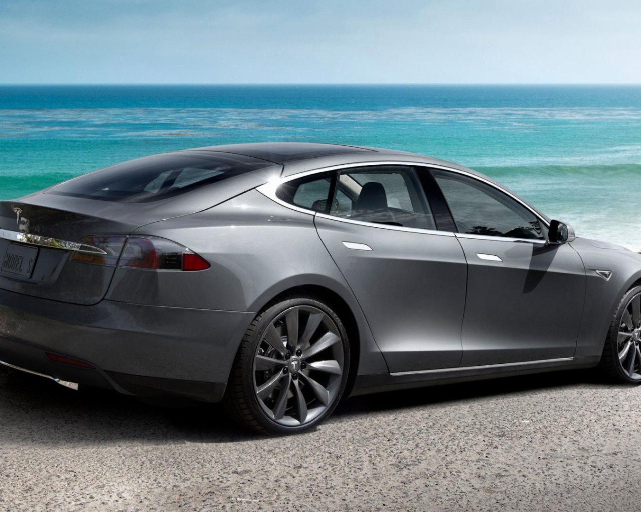 Электрокар Tesla Model S на фоне океана   