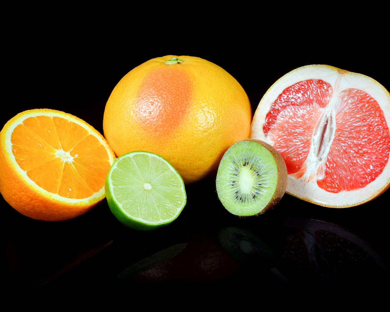 Апельсины, грейпфруты,  лайм и киви на черном фоне