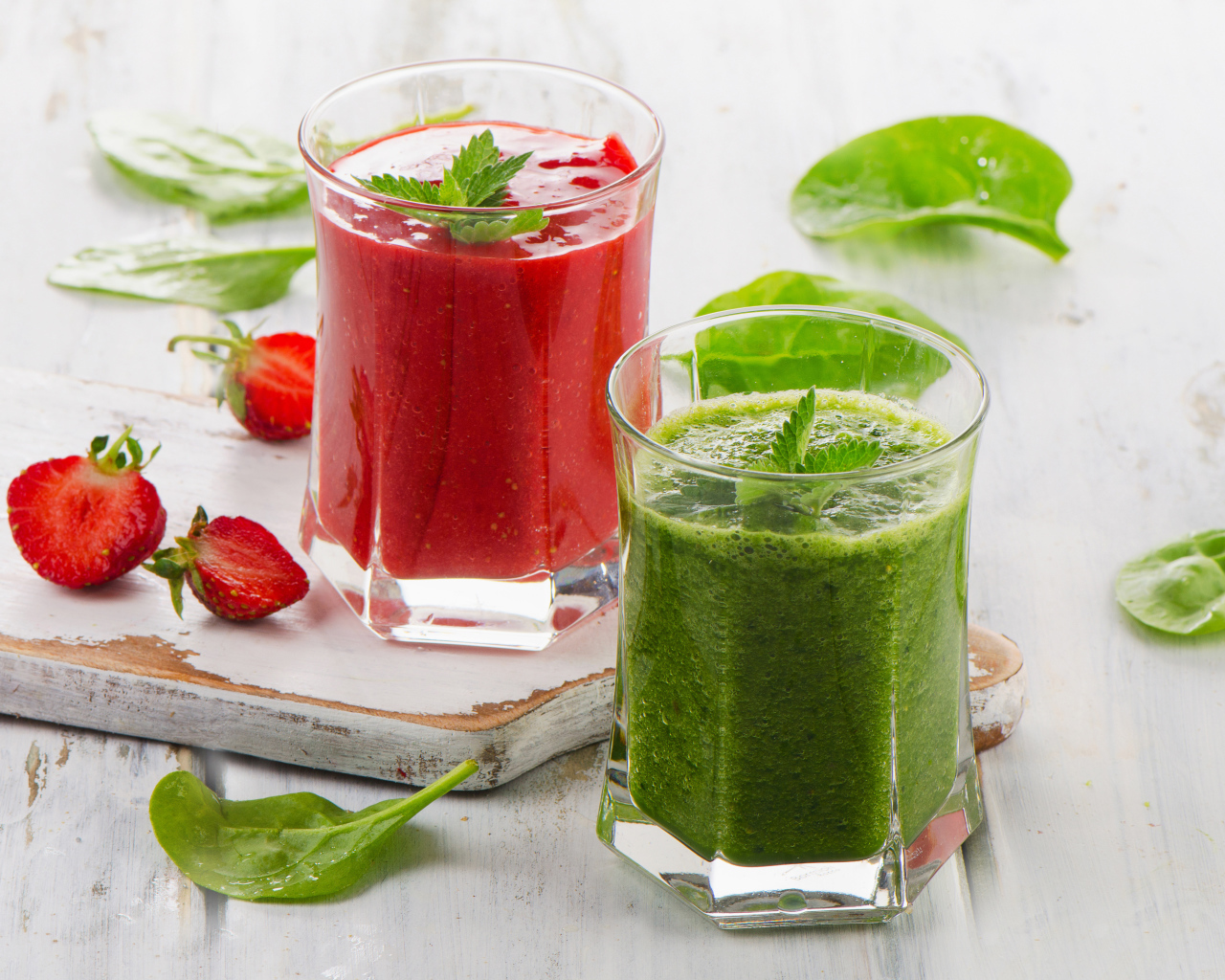 Two glass glasses with strawberry smoothies and smoothies with spinach
