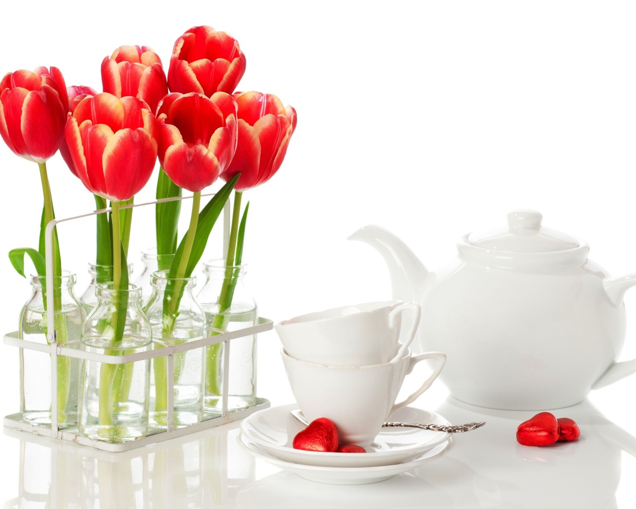 Красные тюльпаны с чайным сервизом на белом фоне