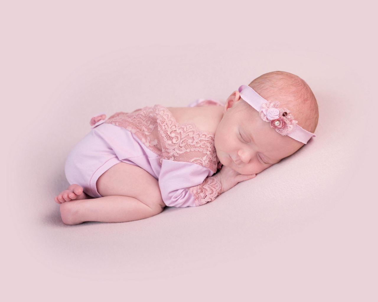 Спящий грудной ребенок на розовом фоне