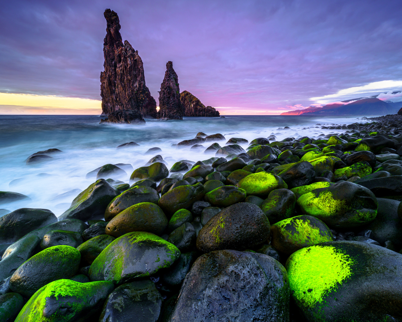 Большие черные камни лежат на берегу острова Мадейра