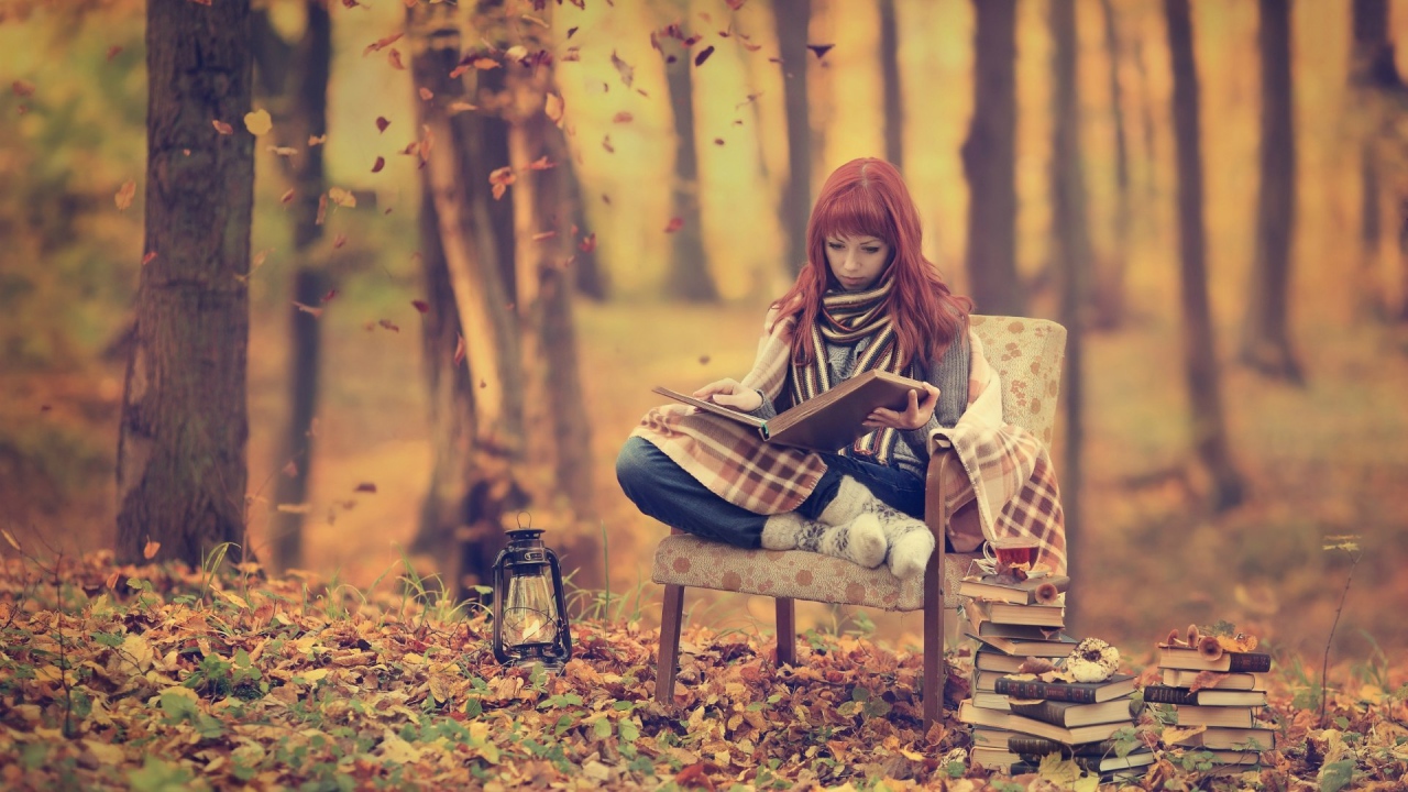 Девушка читает книги в лесу