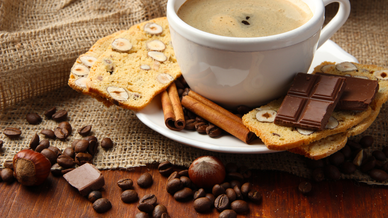 Чашка кофе с выпечкой, кофейными зернами и шоколадом
