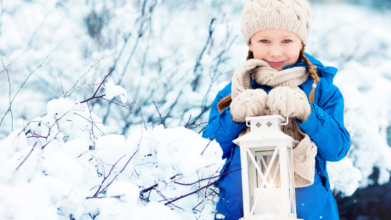 Маленькая девочка в синей куртке с фонарем  в руках зимой