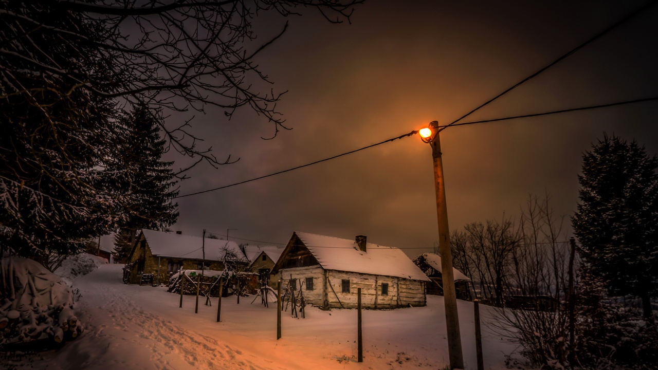 Покрытые снегом дома на зимней улице ночью