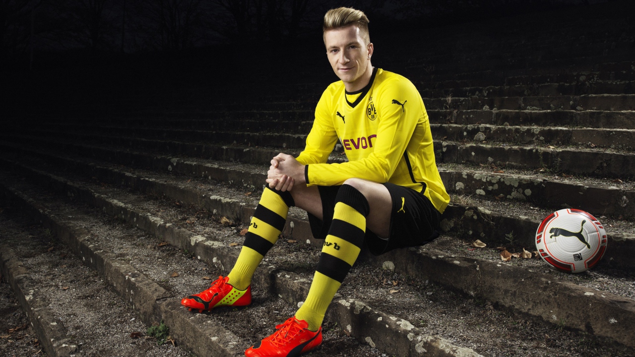 Немецкий футболист Марко Ройс сидит на ступеньках 