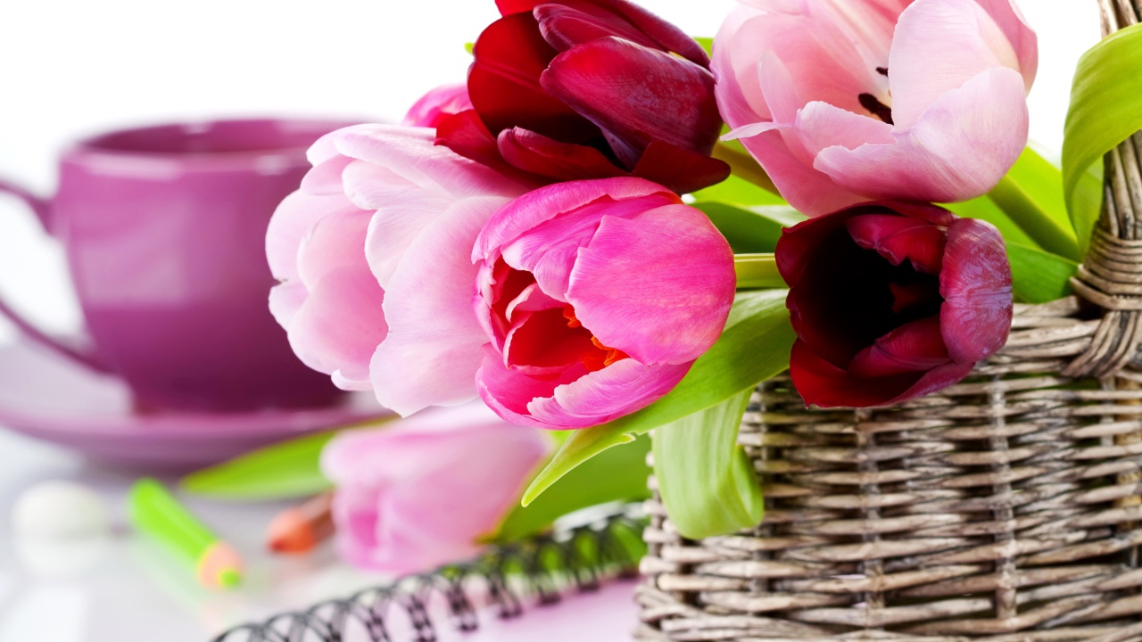 Букет разноцветных тюльпанов в корзине на столе с блокнотом