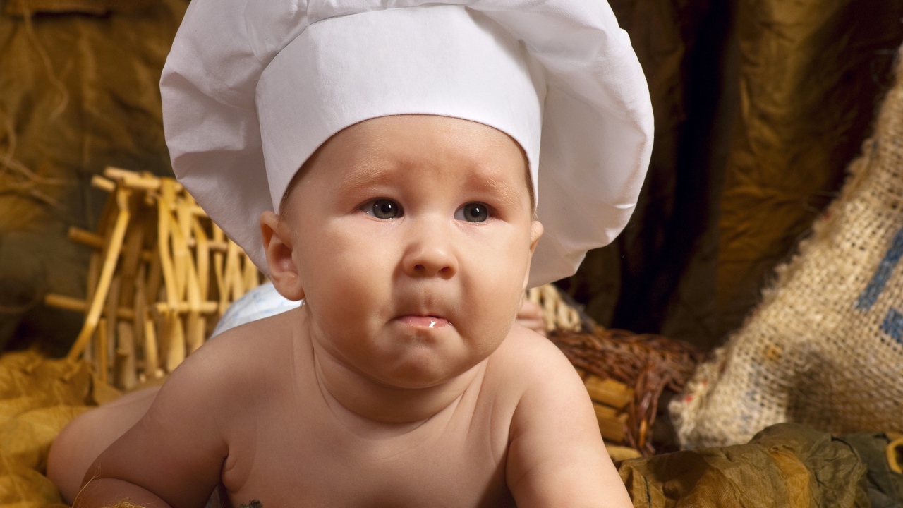 A baby in a white chef's hat