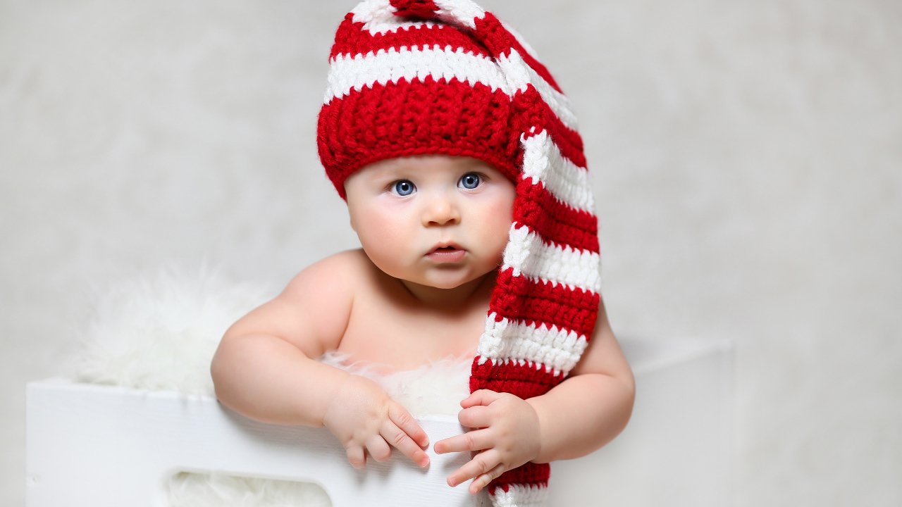 Голубоглазый младенец в длинной вязаной шапке