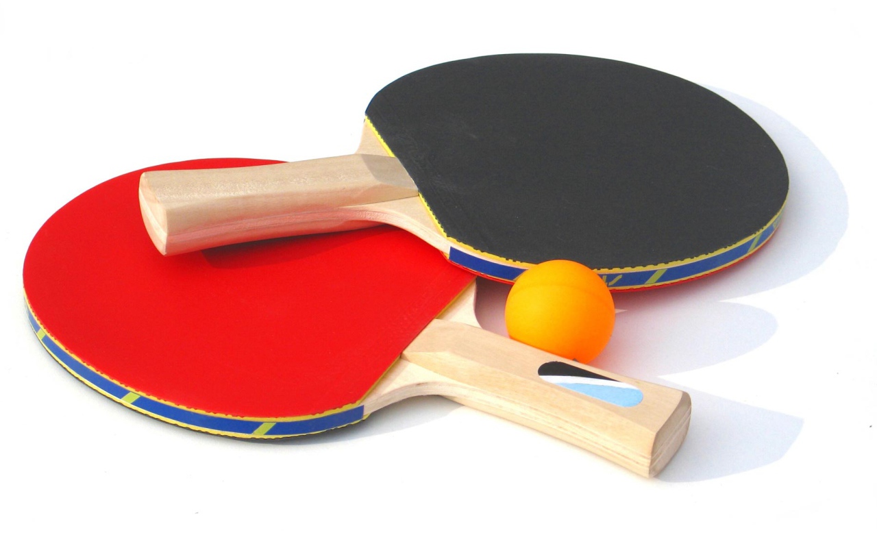 Красная и желтая ракетки и мяч на белом фоне  