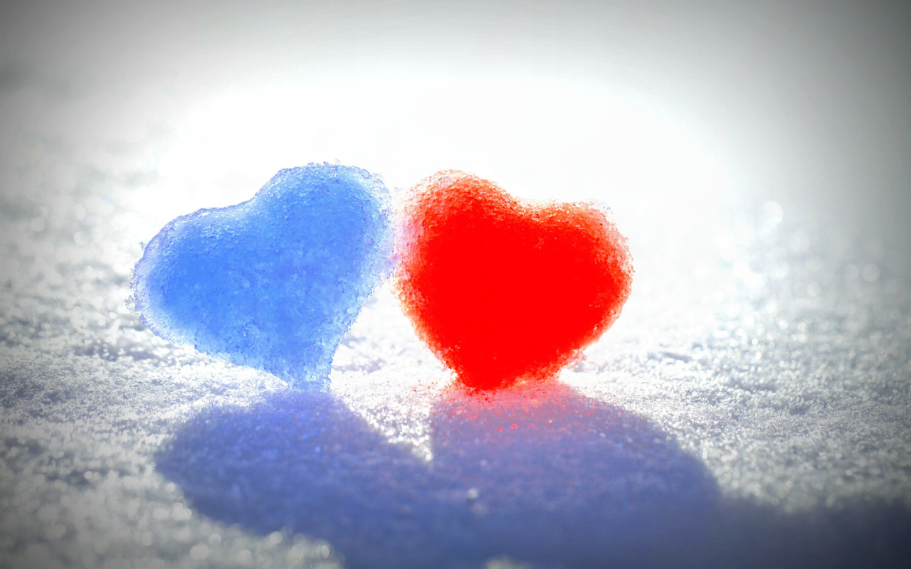 Голубое и красное сердце на белом снегу 