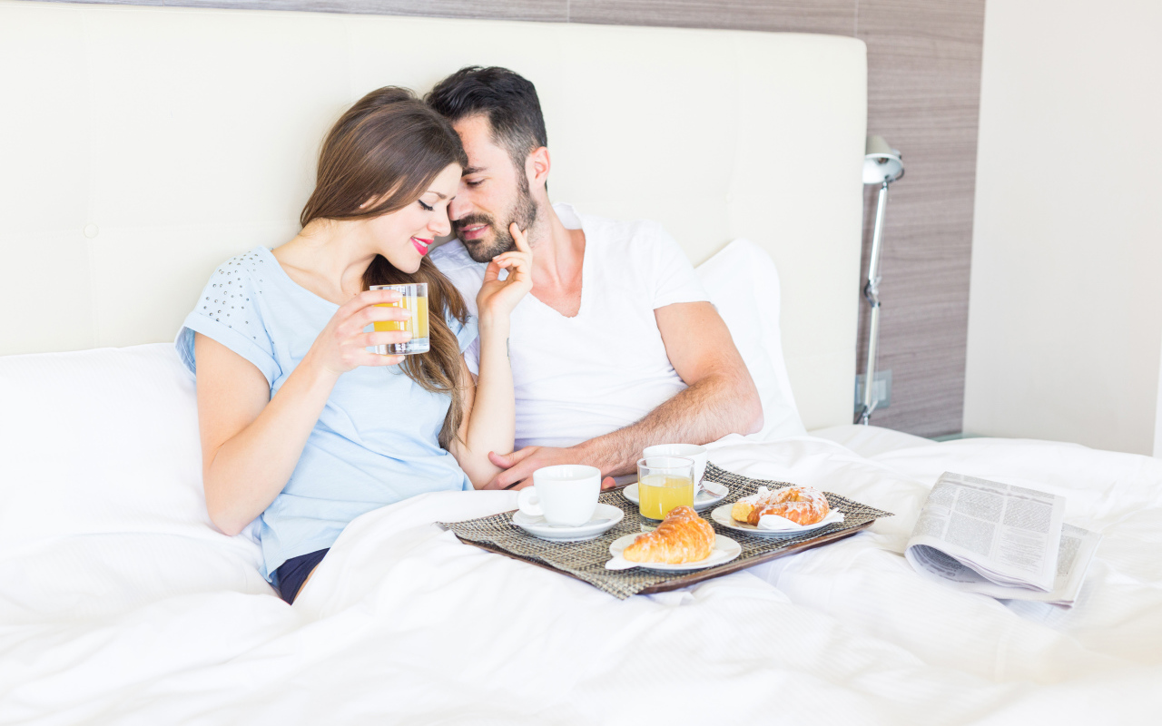 Couple in love with breakfast in bed