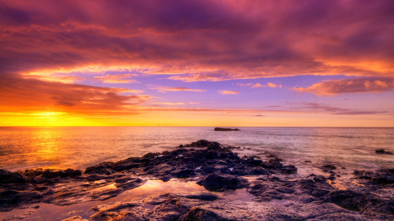 Разноцветный закат на каменистом побережье
