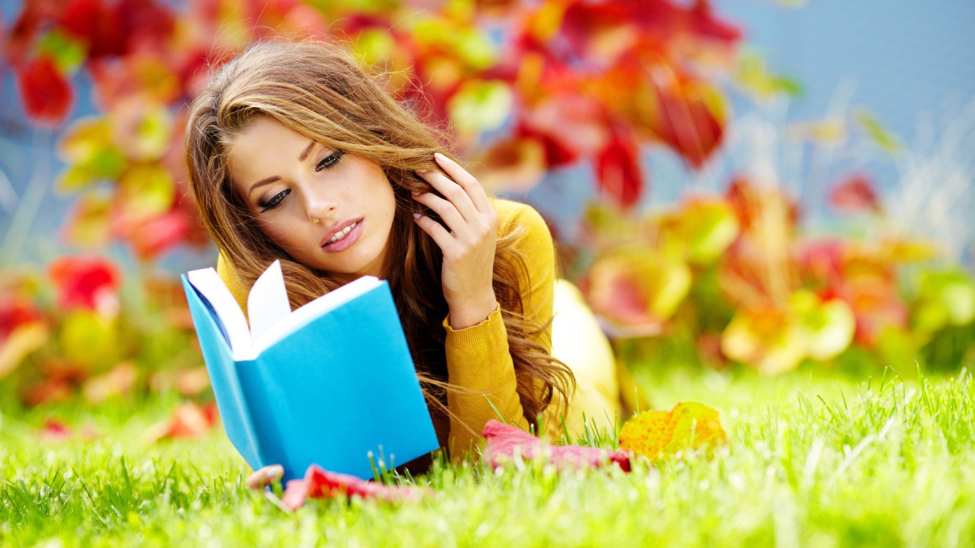 Девушка на траве читает книгу