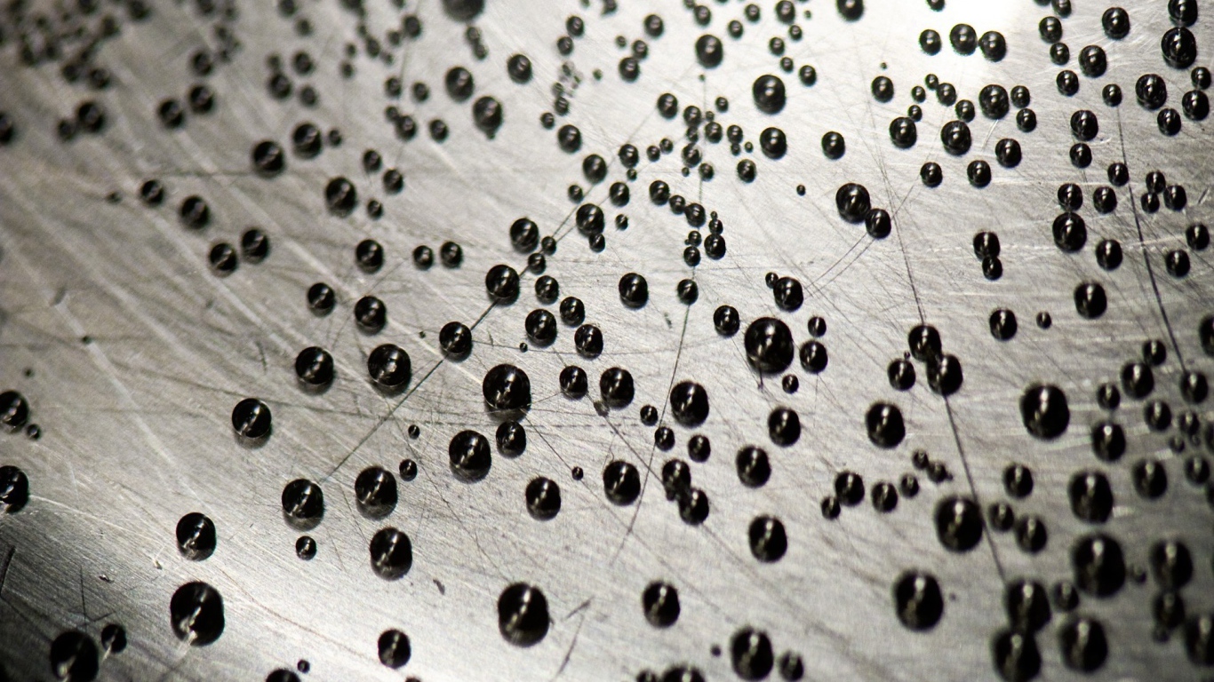 Мелкие черные шарики на серой поверхности