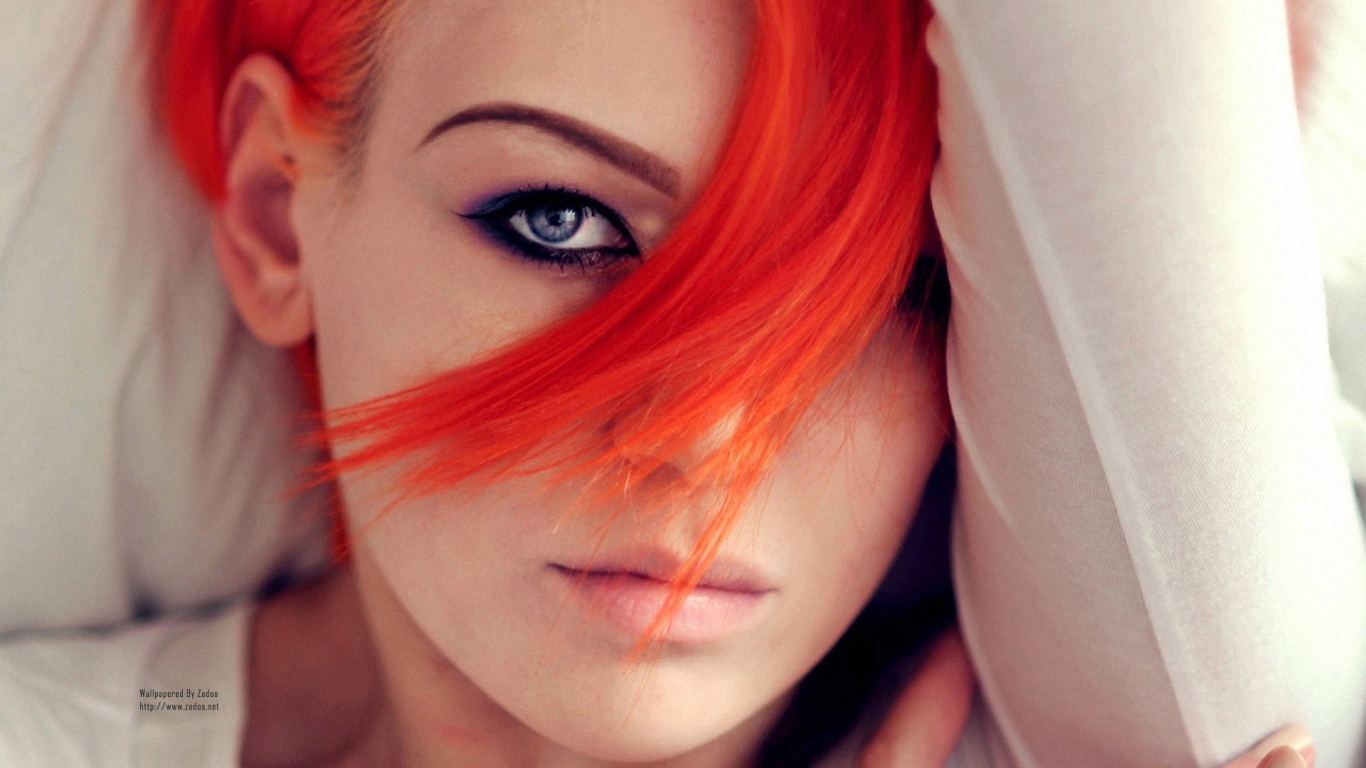 Прядь оранжевых волос на лице у девушки