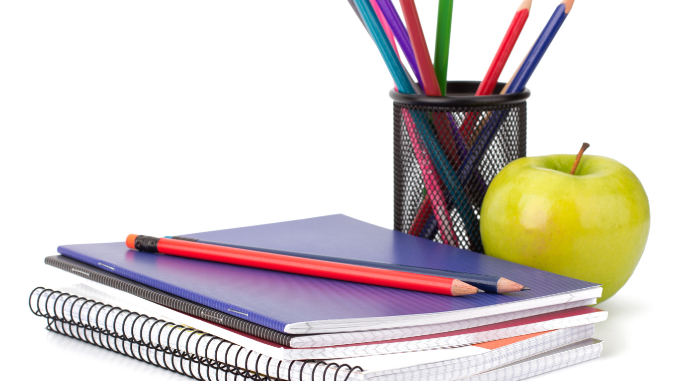 Notebooks, pencils and a green apple on a white background