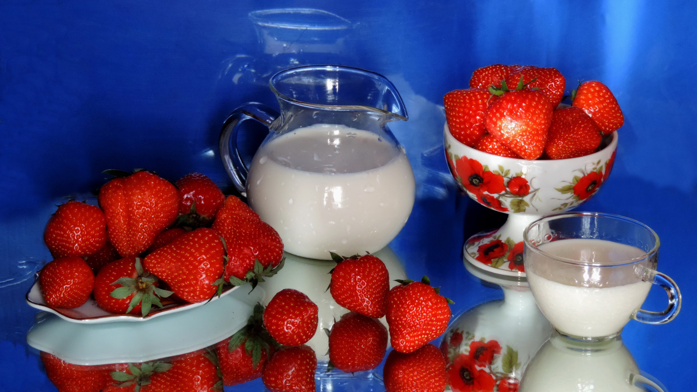 Свежие аппетитные ягоды клубники на столе с молоком
