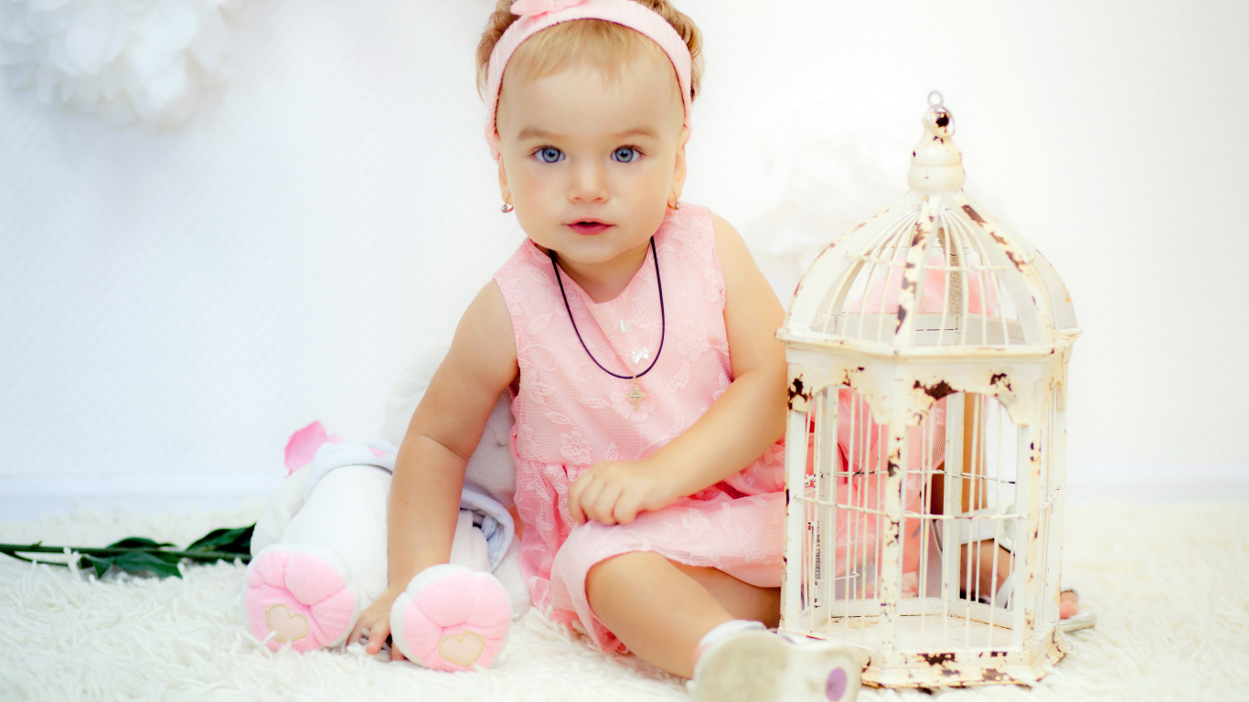 Красивая маленькая девочка в розовом платье с клеткой