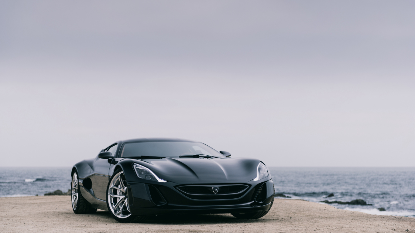 Черный спортивный автомобиль Rimac Concept One на фоне океана