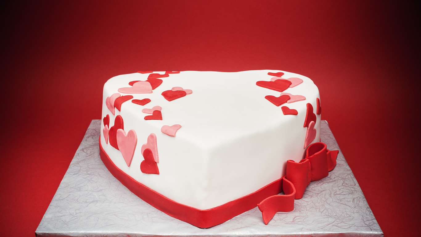 Красивый торт в форме сердца на красном фоне