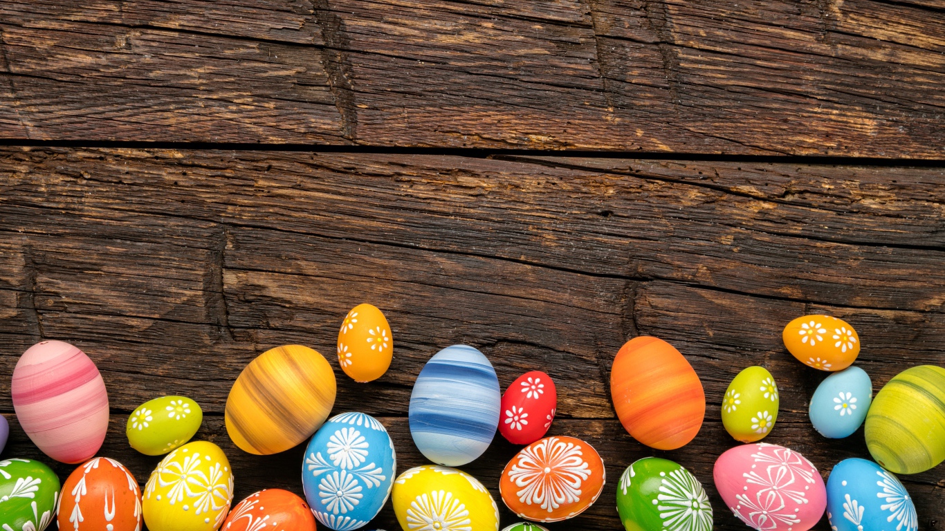 Разноцветные пасхальные яйца на деревянном столе
