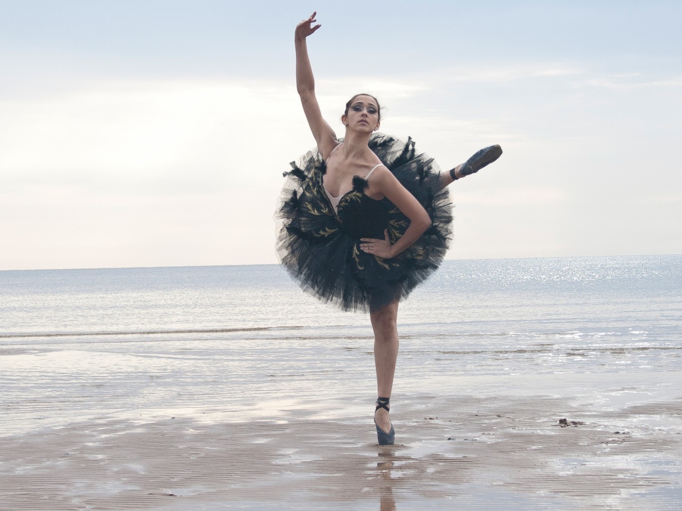 Ballerina in black on the beach