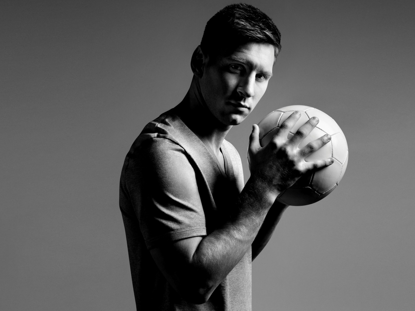 Football player Lionel Messi with the ball in his hands black and white photo
