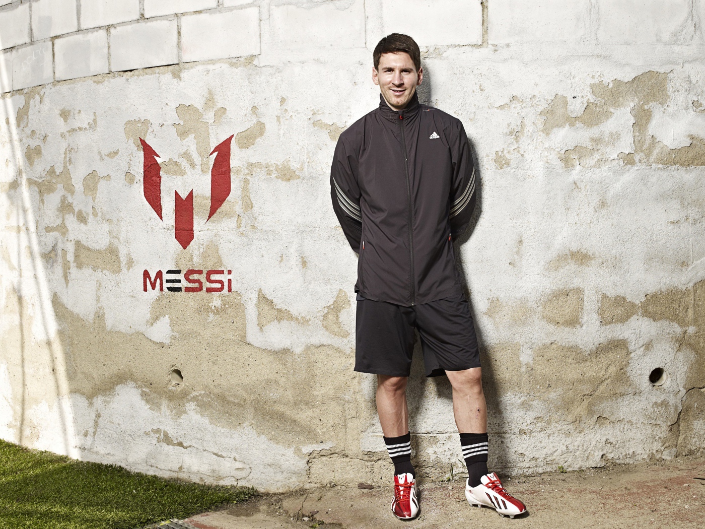 Футболист Лионель Месси позирует  на фоне стены 