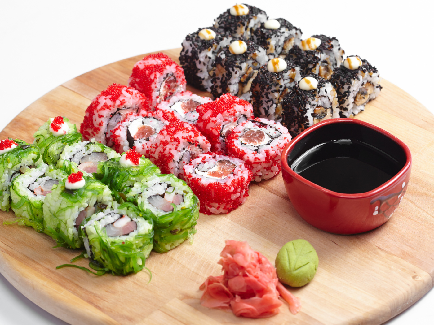 Different appetizing sushi on a wooden board with soy sauce