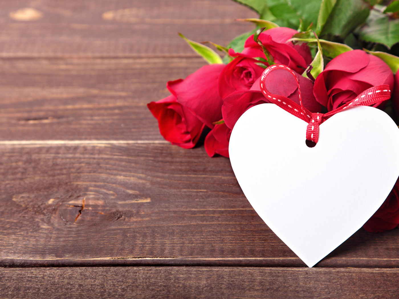 Букет розовых роз с бумажным сердцем на деревянном фоне