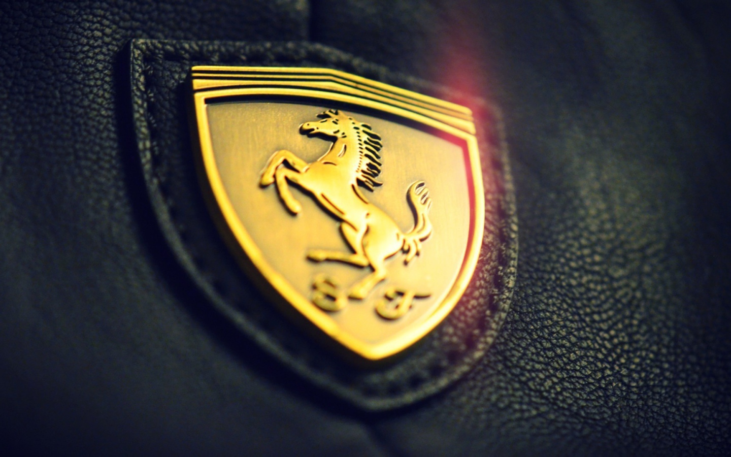 Golden symbol of Ferrari on black leather