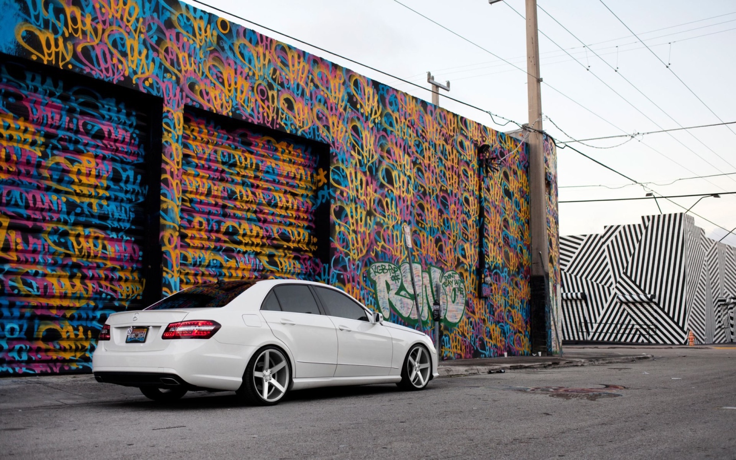 Белый Mercedes-Benz у раскрашенного гаража