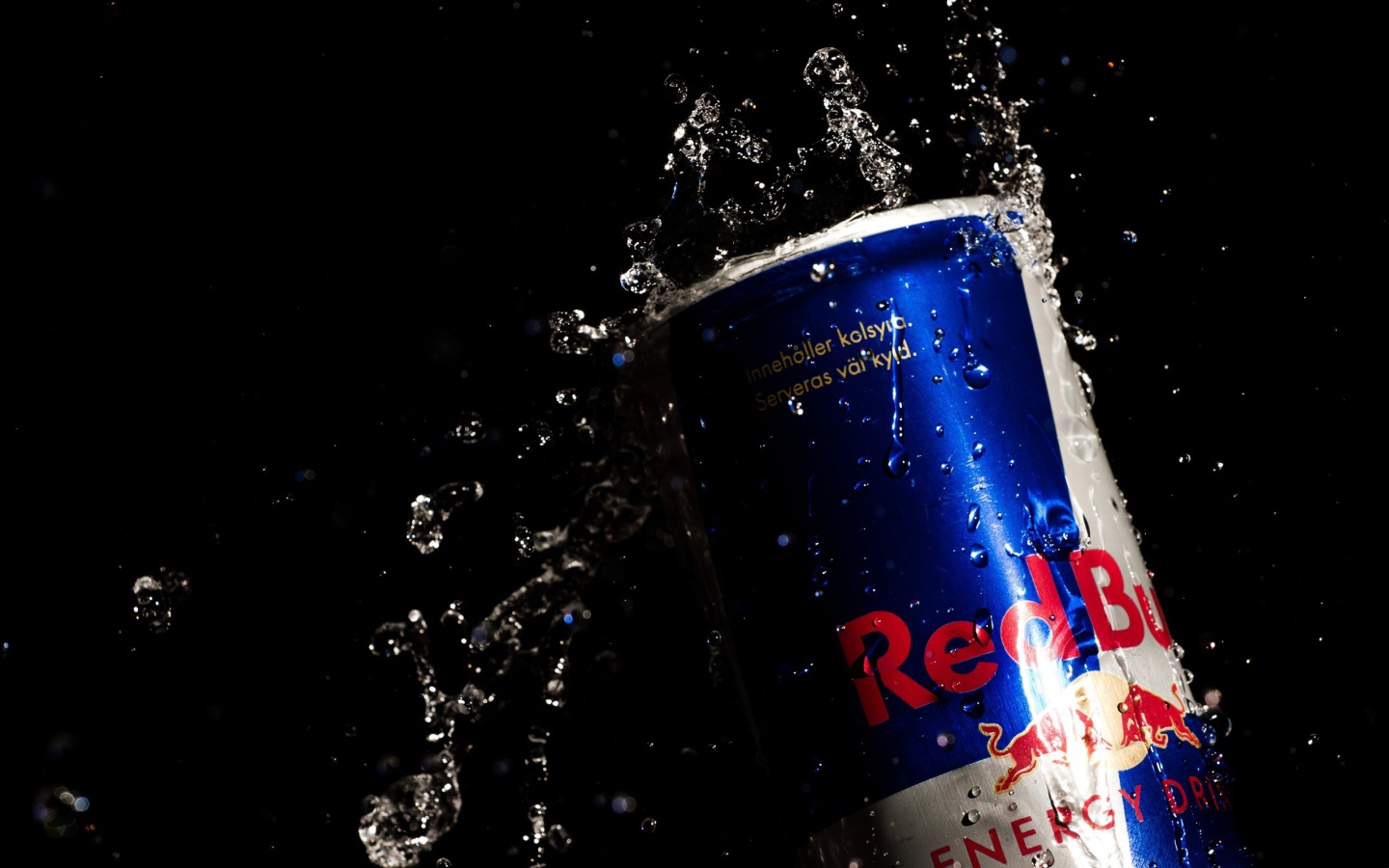 Напиток Red Bull в каплях воды