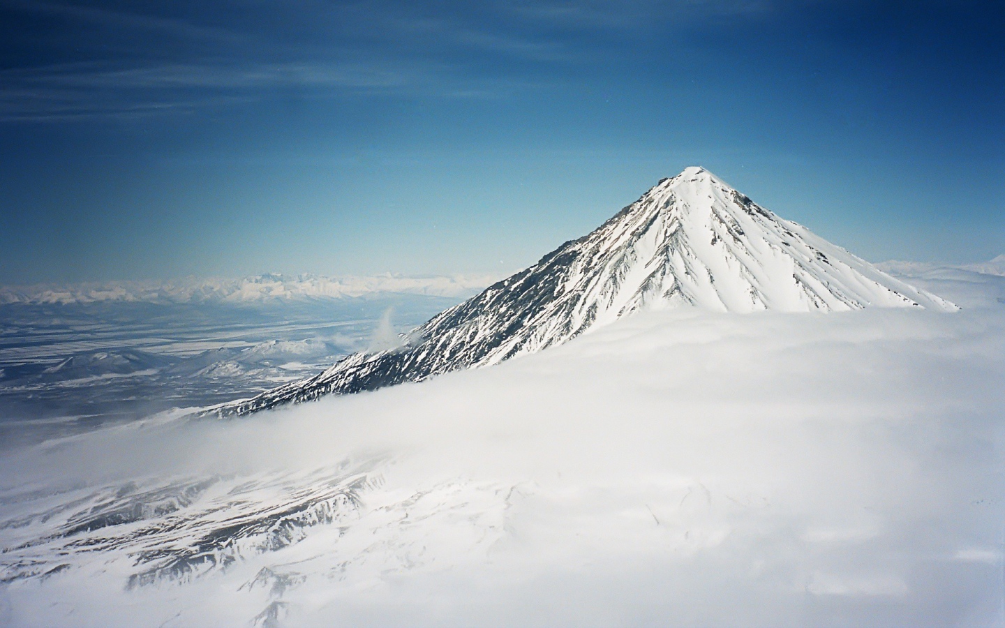 Вершина покрытой снегом горы в облаке